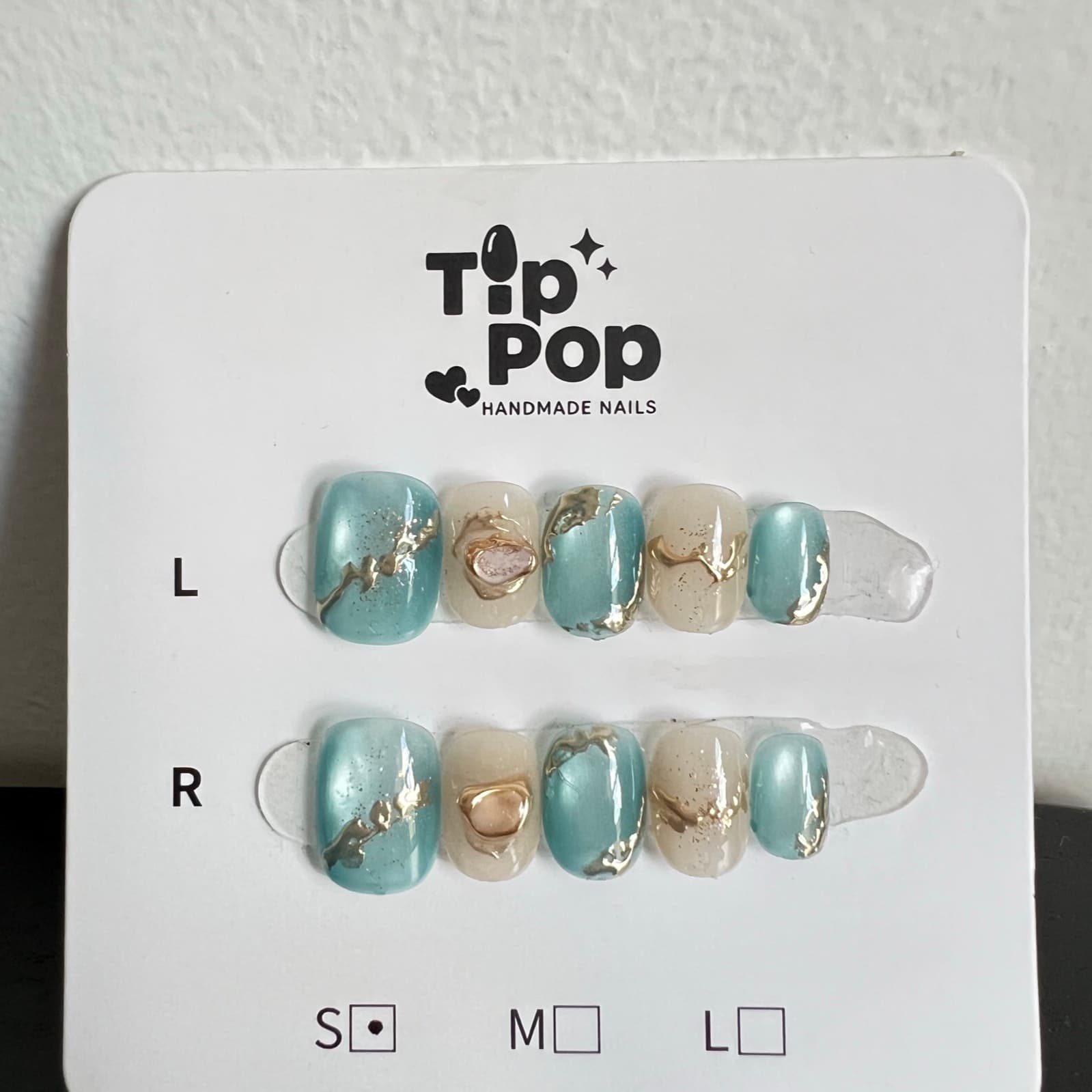 Aqua Gold Stone press-on nail set on a TipPop Nails card