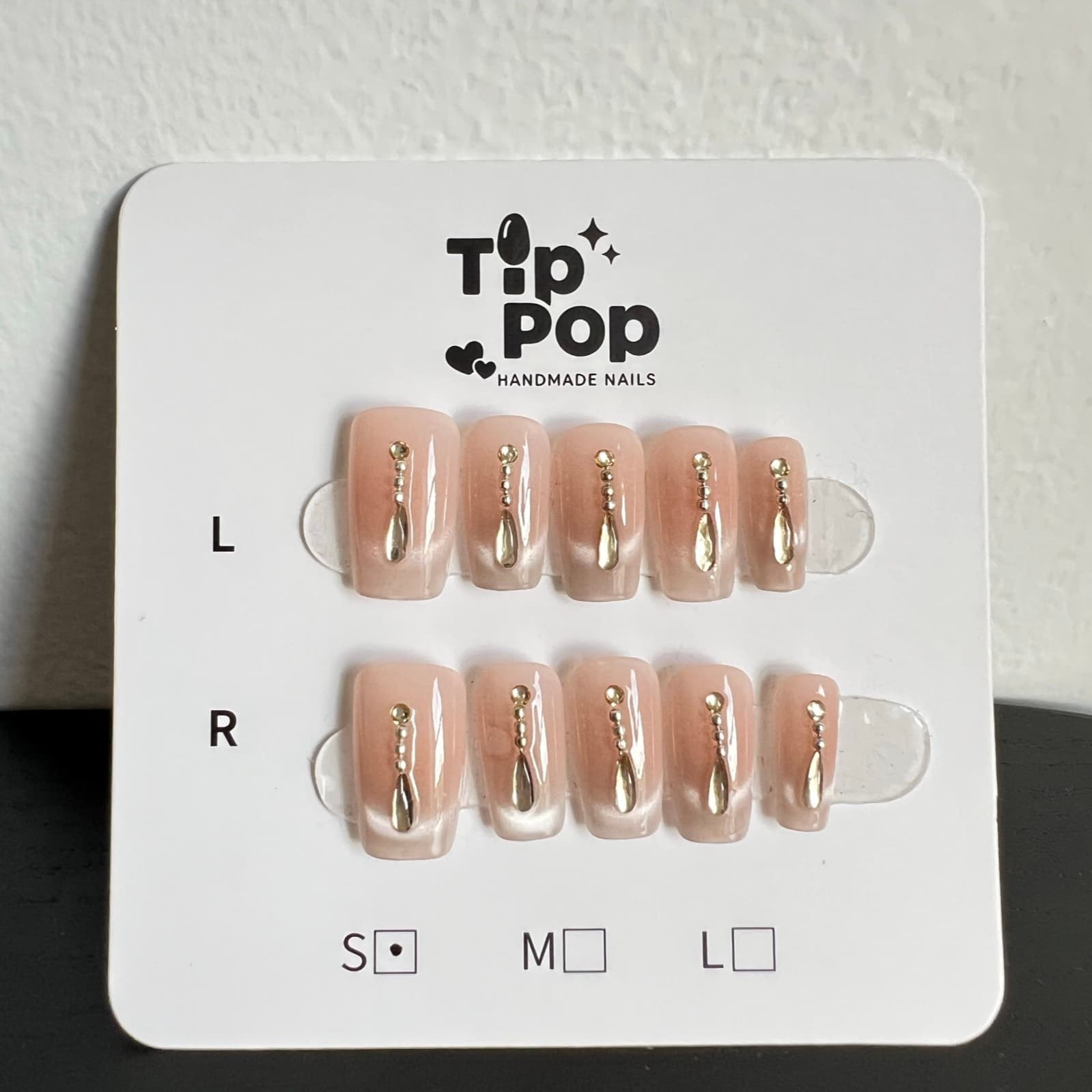 Gilded Teardrop Nude press-on nail set on a TipPop Nails card